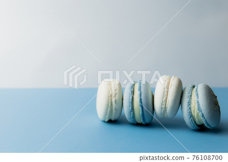 White and blue macaroons on the table, macaroons on blue background White and blue macaroons on the table, macaroons on blue background 76108700