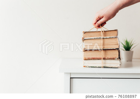 Hand holding books, concept of learning, education, science, wisdom, knowledge Hand holding books, concept of learning, education, science, wisdom, knowledge 76108897