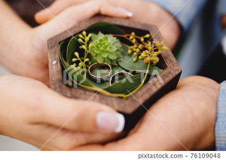 Wedding couple is holding their wedding rings 76109048