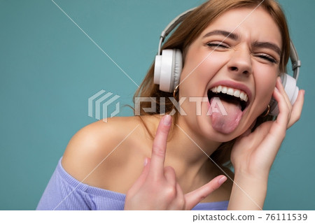 Closeup portrait of attractive emotional young blonde woman wearing blue crop top isolated on blue Closeup portrait of attractive emotional young blonde woman wearing blue crop top isolated on blue 76111539