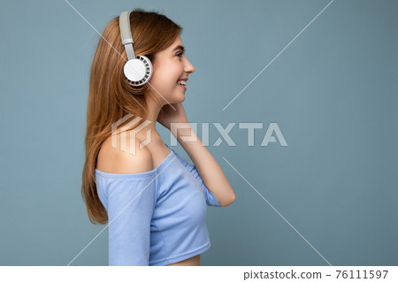 Side-profile photo of beautiful positive smiling young blonde woman wearing blue crop top isolated 76111597