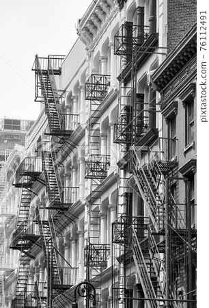 Row of old building with iron fire escapes, black and white picture of New York cityscape, USA. Row of old building with iron fire escapes, black and white picture of New York cityscape, USA. 76112491