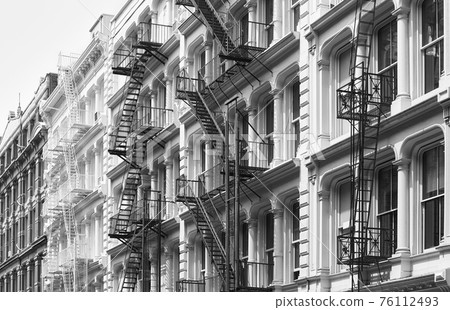 Row of old building with iron fire escapes, black and white picture of New York cityscape, USA. 76112493