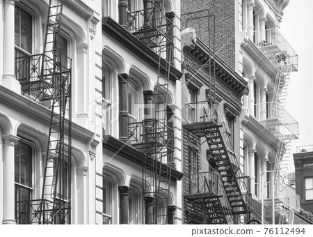 Row of old buildings with iron fire escapes, black and white picture, New York City, USA. Row of old buildings with iron fire escapes, black and white picture, New York City, USA. 76112494