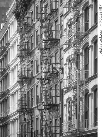 Row of old buildings with iron fire escapes, black and white picture, New York City, USA. Row of old buildings with iron fire escapes, black and white picture, New York City, USA. 76112497