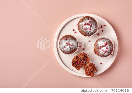 Homemade chocolate cupcakes in baking paper forms and piece of it 76114016