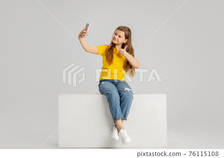 Happy kid, girl isolated on white studio background. Looks happy, cheerful, sincere. Copyspace. Childhood, education, emotions concept 76115108