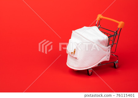 Supermarket cart with protective mask on - shopping during Coronavirus COVID-19 epidemy concept 76115401