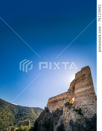 Backlit of old ruined castle on top of the rocks 76115601