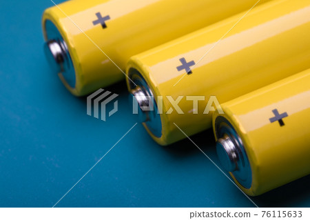 Yellow alkaline batteries on blue background 76115633