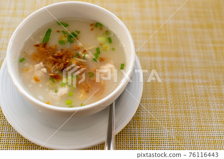 Thai style breakfast pork rice soup with egg on wood table. Thai style breakfast pork rice soup with egg on wood table. 76116443