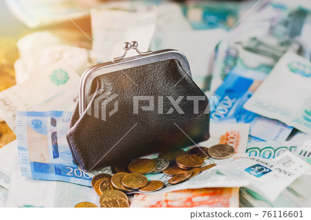 A black old wallet is sitting on a pile of Russian money. Financial savings. A black old wallet is sitting on a pile of Russian money. Financial savings. 76116601