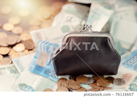A black old wallet is sitting on a pile of Russian money. Financial savings. A black old wallet is sitting on a pile of Russian money. Financial savings. 76116607