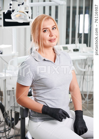 Portrait of female dentist sitting in her dentist office. Portrait of female dentist sitting in her dentist office. 76116987