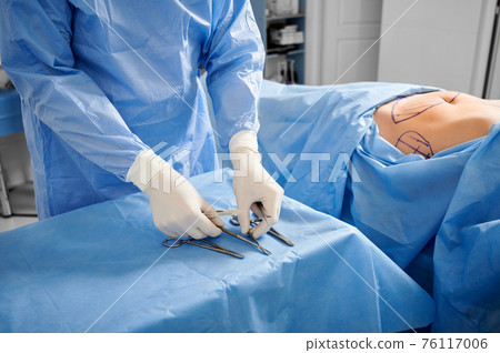 Doctor preparing instruments for plastic surgery in operating room. Doctor preparing instruments for plastic surgery in operating room. 76117006