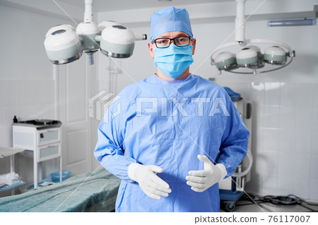 Male surgeon in medical mask standing in operating room. 76117007