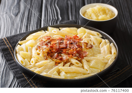 Authentic Swiss alplermagronen is pasta with potatoes and cheese and fried onions, bacon close-up on the table. horizontal Authentic Swiss alplermagronen is pasta with potatoes and cheese and fried onions, bacon close-up on the table. horizontal 76117400