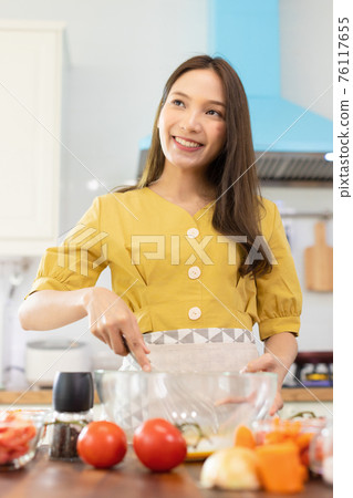 Woman cooking rice with vegetables in kitchen 76117655