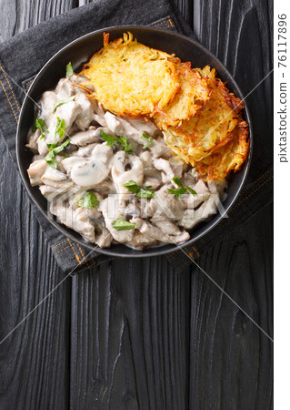 Zurich Ragout or Zurcher Geschnetzeltes Swiss simple ragout or stew recipe in a white sauce is made with mushrooms and white wine closeup in the plate. Vertical top view Zurich Ragout or Zurcher Geschnetzeltes Swiss simple ragout or stew recipe in a white sauce is made with mushrooms and white wine closeup in the plate. Vertical top view 76117896