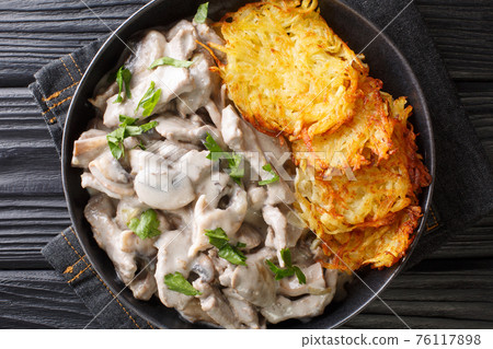 Swiss Zurich veal with mushrooms in a creamy sauce with potato pancakes close-up in a plate. horizontal top view Swiss Zurich veal with mushrooms in a creamy sauce with potato pancakes close-up in a plate. horizontal top view 76117898