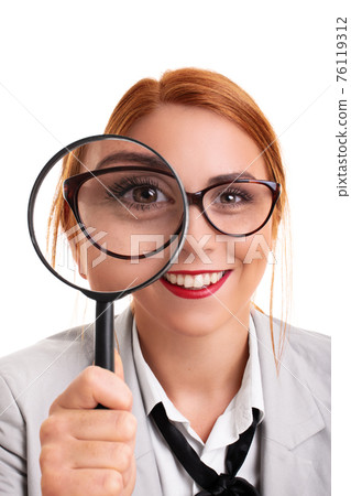 Young businesswoman smiling and looking through magnifying glass Young businesswoman smiling and looking through magnifying glass 76119312