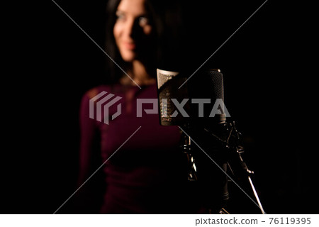 Portrait of woman recording a song in a professional studio 76119395