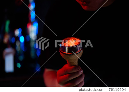 Shisha hookah, red hot coals. Man blows coals for sparks fly. Shisha hookah, red hot coals. Man blows coals for sparks fly. 76119604