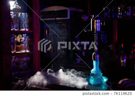 Hookah on the background of a bar, light, smoke, smog Hookah on the background of a bar, light, smoke, smog 76119620