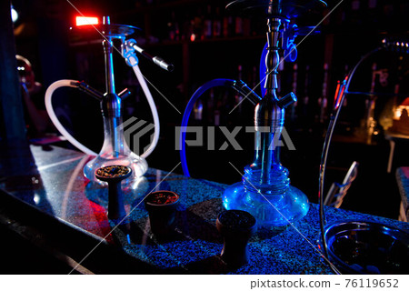 Group of eastern hookahs on table of a bar. Group of eastern hookahs on table of a bar. 76119652