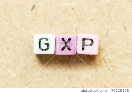 Color alphabet letter block in word GXP on wood background 76120138