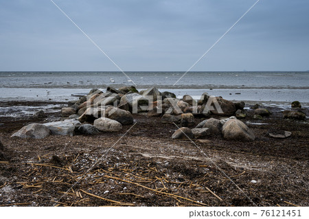 Boulders at Lomma Beach, Malmo, Sweden. Blue sky and ocean in the background 76121451