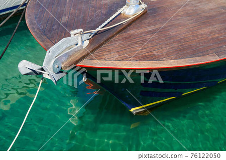 Wooden motorboat moored to pier on sea Wooden motorboat moored to pier on sea 76122050