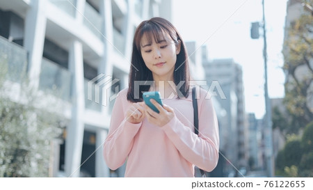 A woman looking for a way with a smartphone A woman looking for a way with a smartphone 76122655