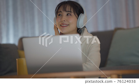 年輕女子享受深夜音樂 76124038
