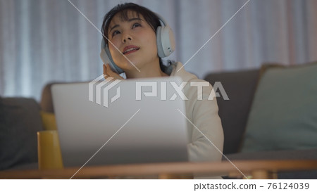 年輕女子享受深夜音樂 76124039