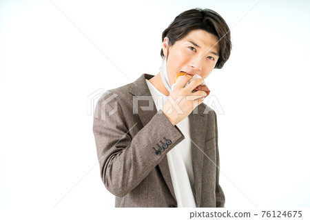 一個偶然的商人在他的下巴上吃一個漢堡,漢堡包著氨基甲酸乙酯面具 一個偶然的商人在他的下巴上吃一個漢堡,漢堡包著氨基甲酸乙酯面具 76124675