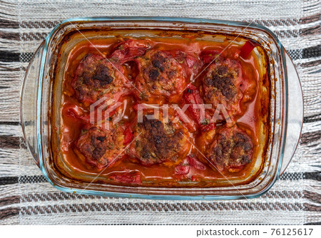Meatballs baked in form in the oven with a gravy of tomato paste, tomatoes, onions and spices. Meatballs baked in form in the oven with a gravy of tomato paste, tomatoes, onions and spices. 76125617