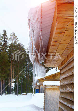 melting Icicles, Icicle hanging from roof, spring drops. warming in the spring. Vertical photo melting Icicles, Icicle hanging from roof, spring drops. warming in the spring. Vertical photo 76125735