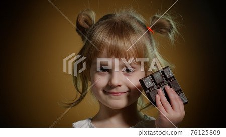 Child kid girl with chocolate bar showing ok gesture sign, satisfied teen girl making faces, smiling Child kid girl with chocolate bar showing ok gesture sign, satisfied teen girl making faces, smiling 76125809