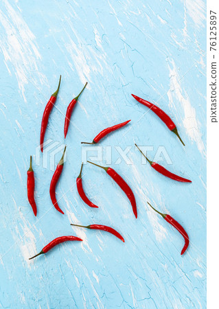 chili pepper on a blue background. Spicy food, Mexican cuisine. vertical photo chili pepper on a blue background. Spicy food, Mexican cuisine. vertical photo 76125897