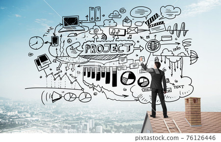 Rear view of businessman on house roof drawing his new business strategy. Mixed media 76126446