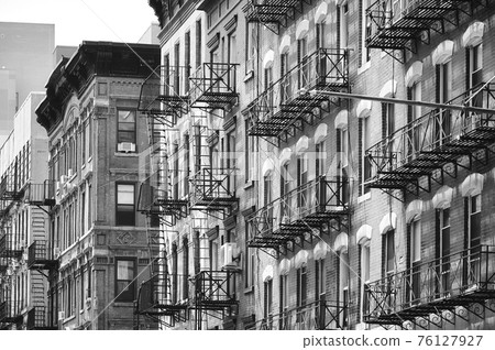 Black and white picture of New York old buildings with fire escapes, USA. Black and white picture of New York old buildings with fire escapes, USA. 76127927