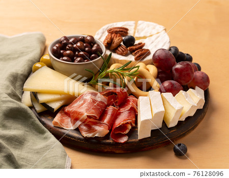 Charcuterie board with jamon, pork sausage with pepper, fuet, cheese and berries 76128096