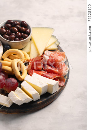 Charcuterie board with spanish jamon, brie cheese and berries Charcuterie board with spanish jamon, brie cheese and berries 76128100