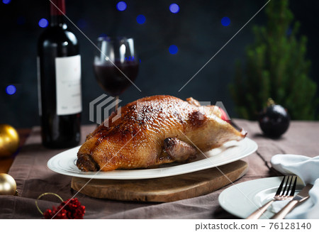 Crispy roasted Duck on a white plate ready for serving on Christmas 76128140