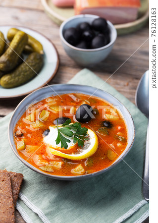 Solyanka, Russian soup with sausage, olives and capers Solyanka, Russian soup with sausage, olives and capers 76128163