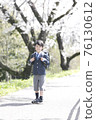 A new first grade boy dancing in the spring cherry blossoms full bloom park 76130612