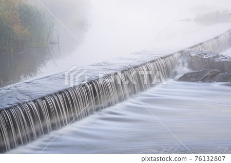 Mornig fog over a river dam Mornig fog over a river dam 76132807