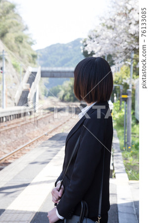 Business person standing on the platform of the station Business person standing on the platform of the station 76133085