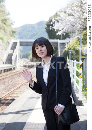 Business person waving at the platform of the station 76133088